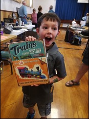 An excited youngster with his win in the children&#39;s silent auction raffle